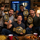 Four men celebrating in a living room, each holding a large fantasy football championship belt. A sports screen in the background displays football scores and a trophy graphic, with bowls of food and red cups on a table in the foreground.