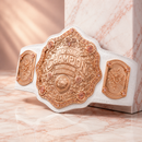 White championship belt with gold emblem on a marble surface