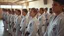 Group of martial arts practitioners in white uniforms standing in a line.